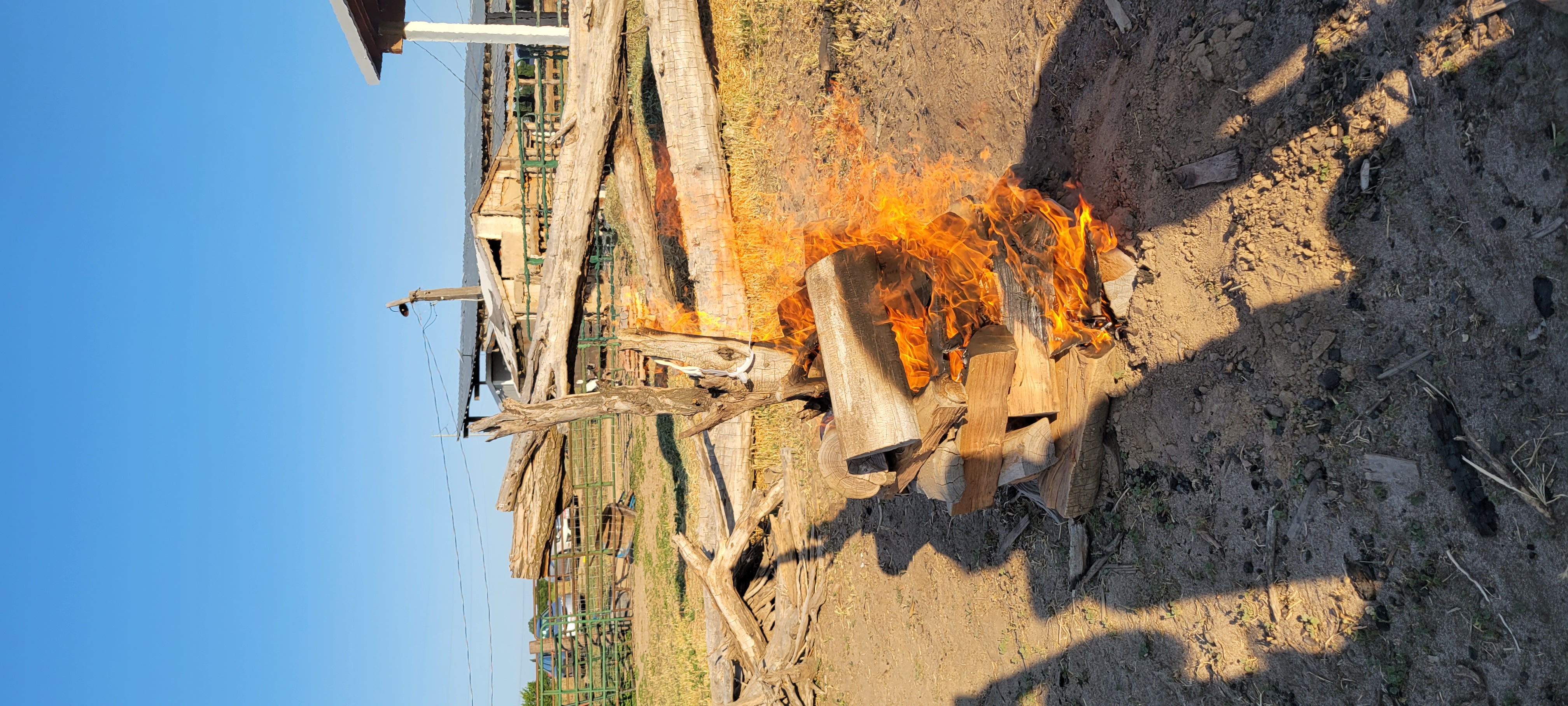 A pyre to burn Asher's tube support. A single log standing vertical with layers of hardwood log rings around. The fire is almost to the top where the tube support rests.
